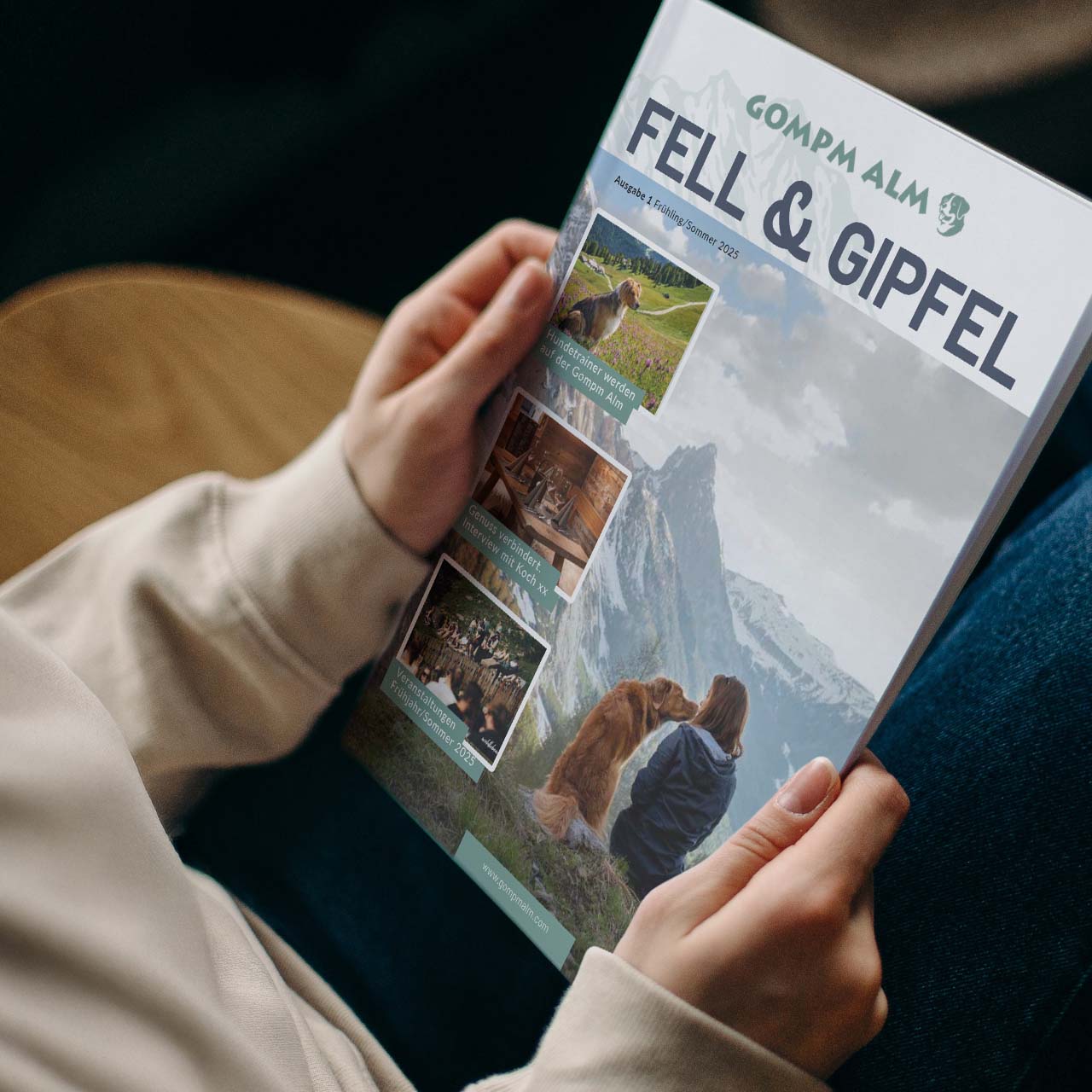 Eine Frau liest das Gompm Alm-Magazin „Fell & Gipfel“